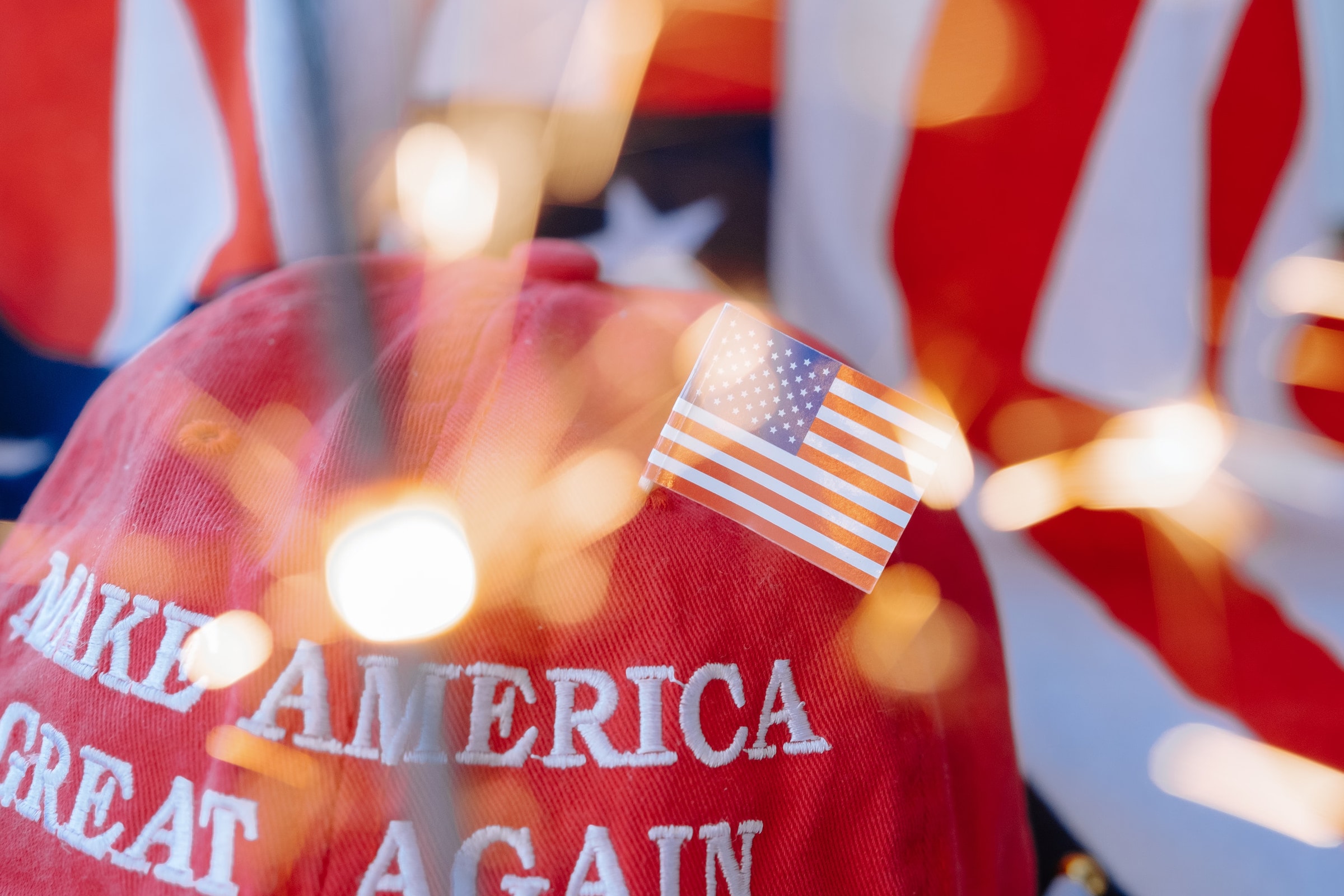 Close-up of a red cap with 'Make America Great Again' and a small American flag.